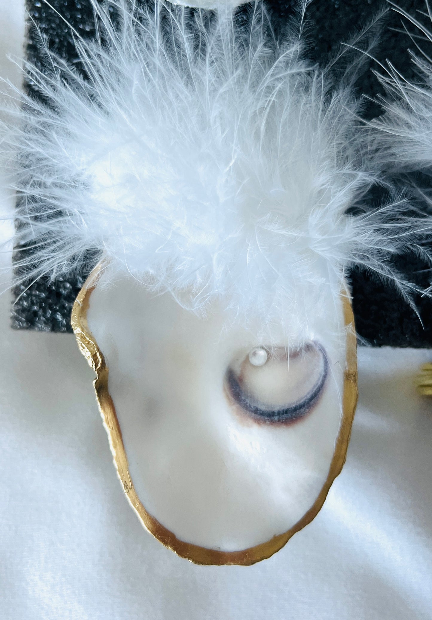 Natural oyster shell napkin rings with feather detail.