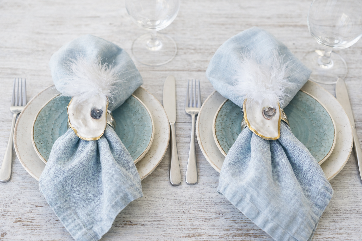 Natural oyster shell napkin rings with feather detail.