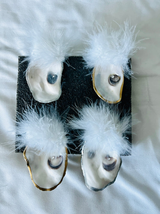 Natural oyster shell napkin rings with feather detail.