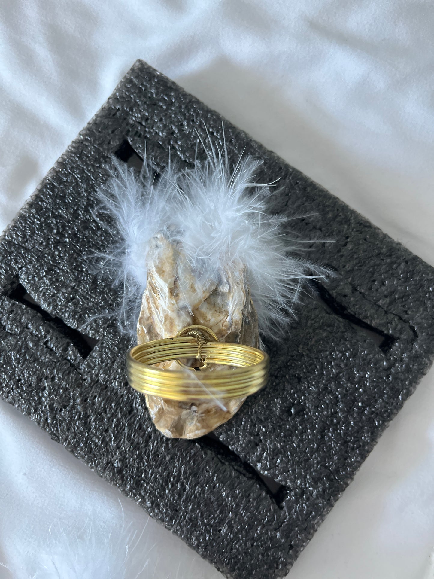 Natural oyster shell napkin rings with feather detail.